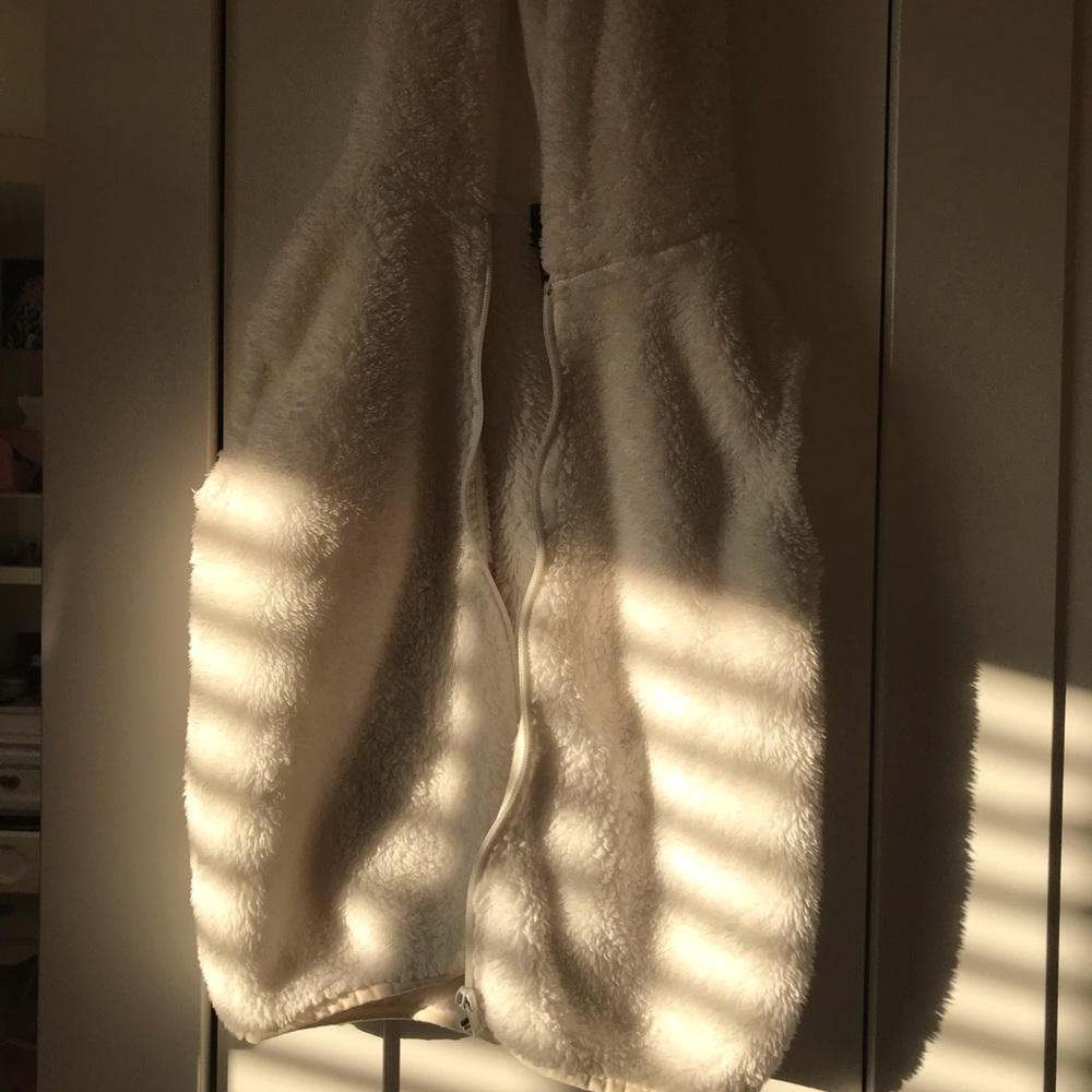 White sleeveless furry sweater.